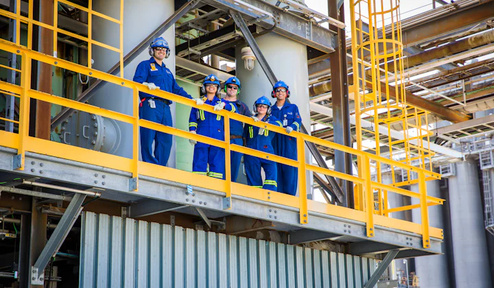 Equipo de ingeniería con casco en una plataforma de planta industrial