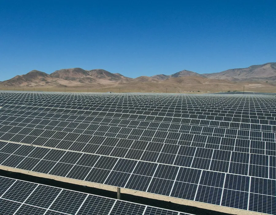 Parque solar fotovoltaico en un paisaje desértico con cerros al fondo