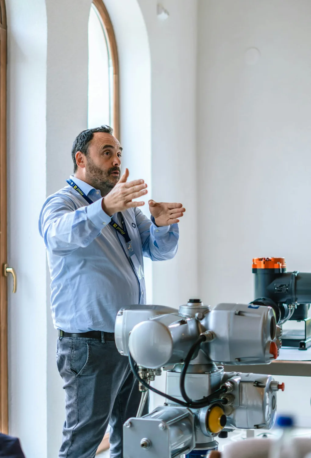 Especialista técnico explicando el funcionamiento de un actuador de válvula industrial